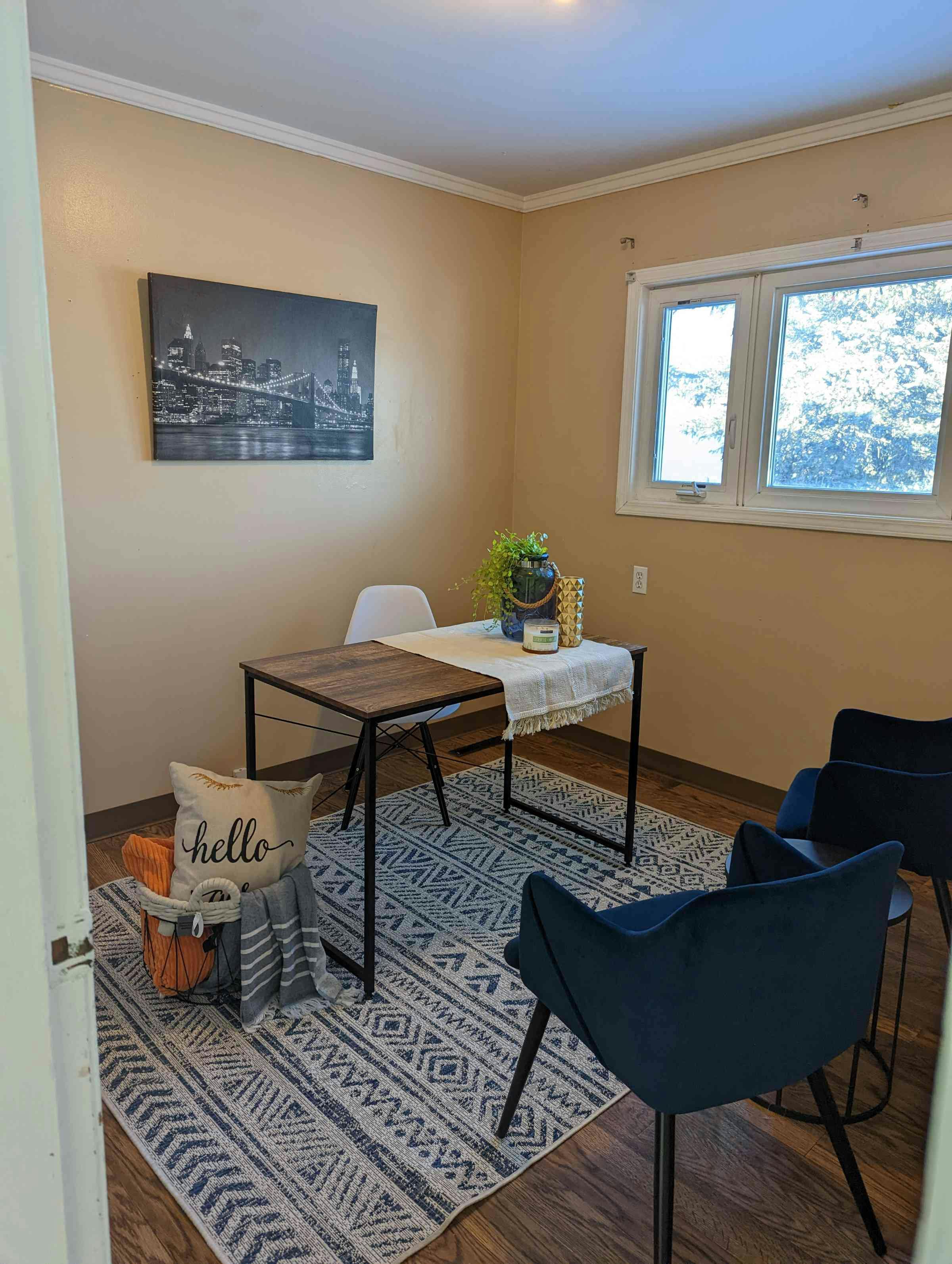 Staged room with antique looking wooden table and blue bucket chairs