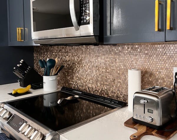 Stainless appliances with deep gray/blue kitchen cupboards