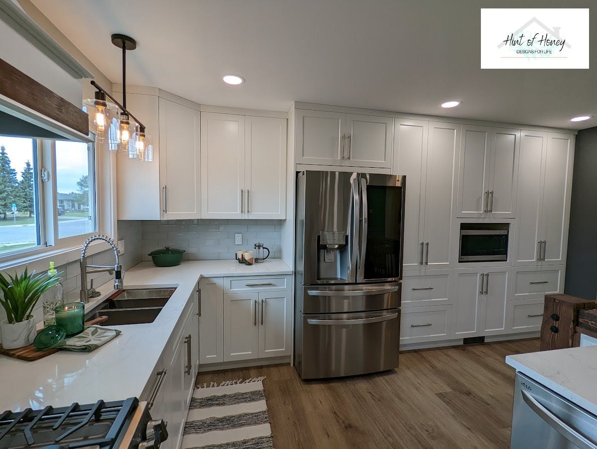 kitchen with white cupboards and stainless fridge and microwave