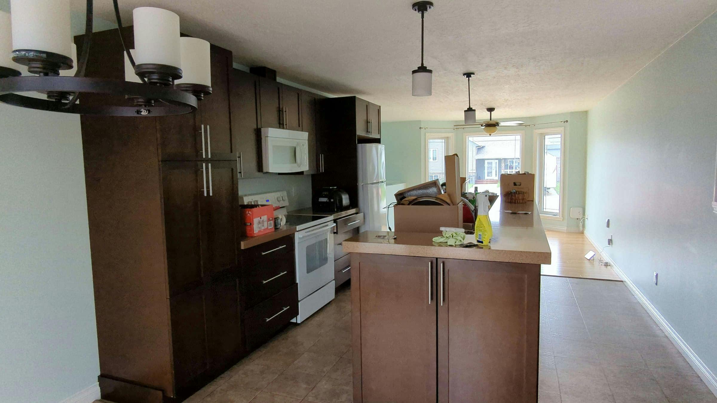 Kitchen with dark wood cabinets and white appliances