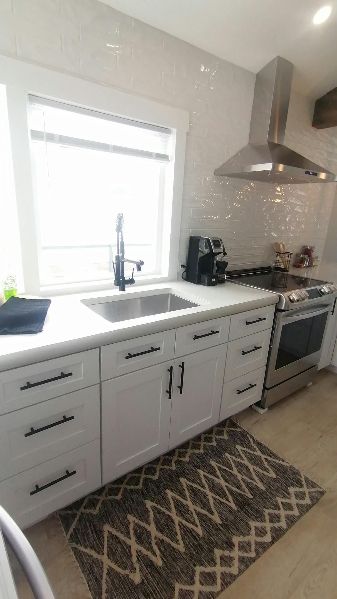 Wide custom sink with white cupboards and black accents