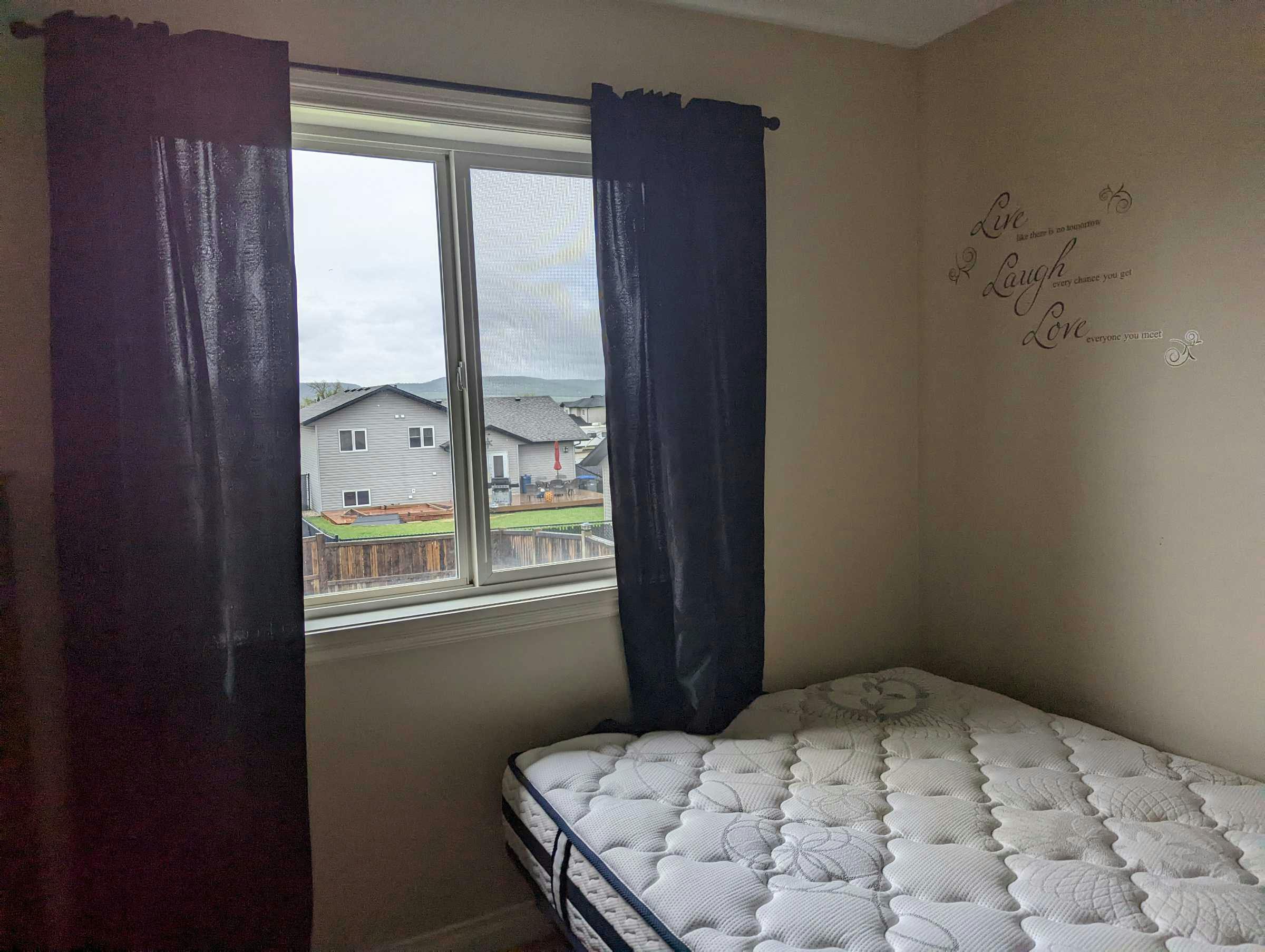 Bedroom with blue curtains and decorative writing on the wall