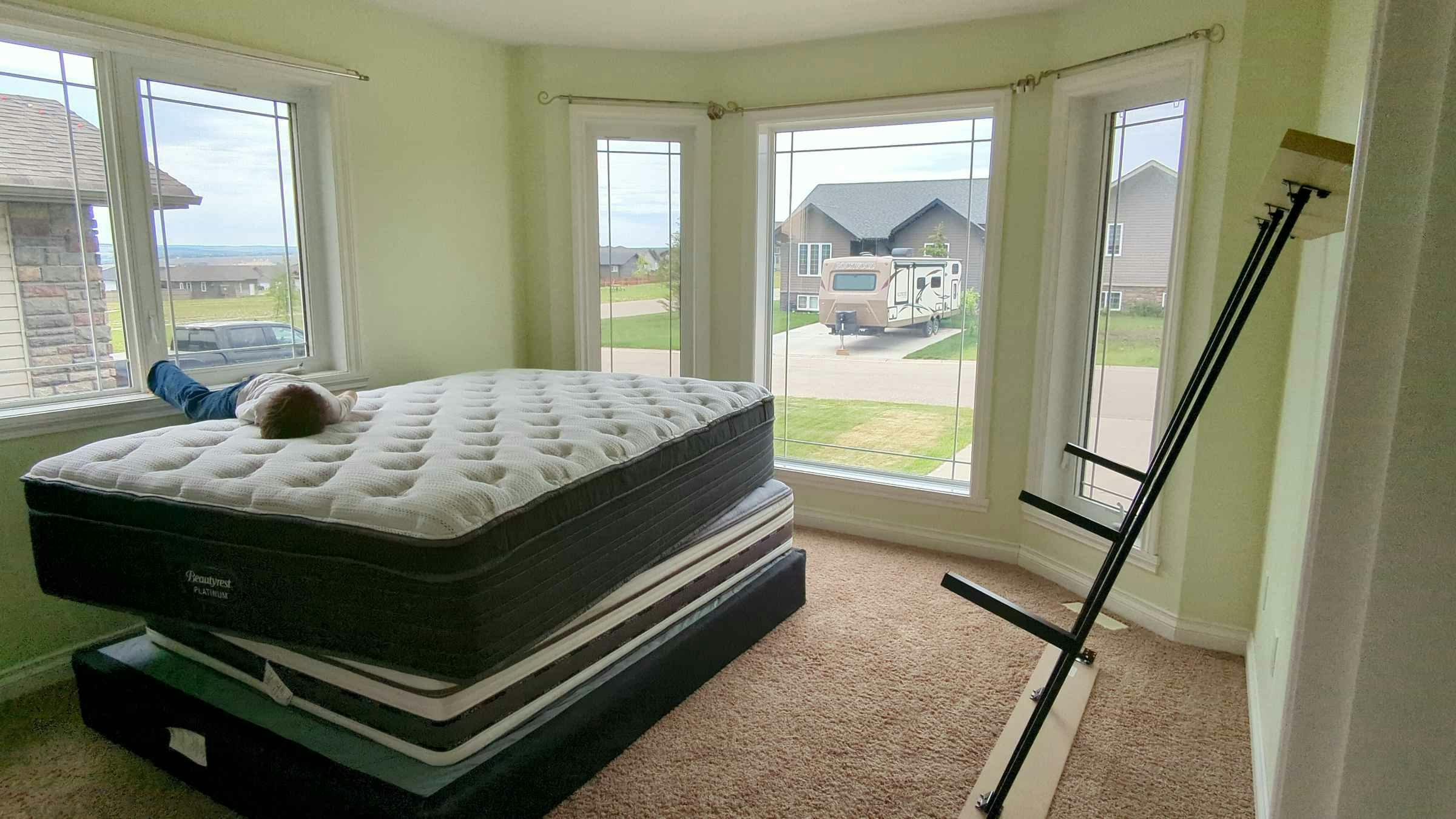 Master bedroom with large open windows and king sized bed