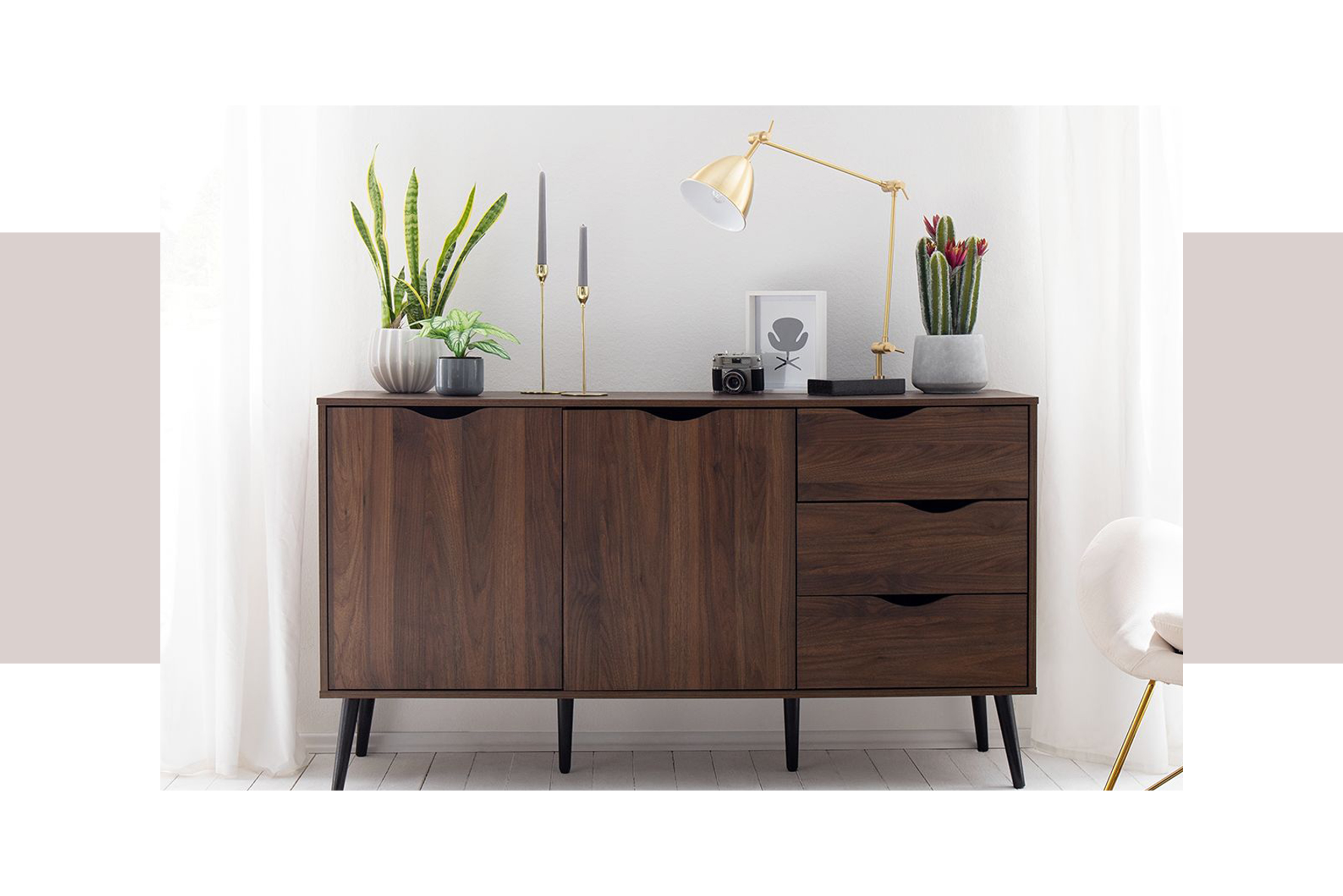 Sideboards aus dunklem Walnussholz verbreiten kombiniert mit goldenen Accessoires und grafischen Prints charmante Retro-Vibes im Wohnzimmer