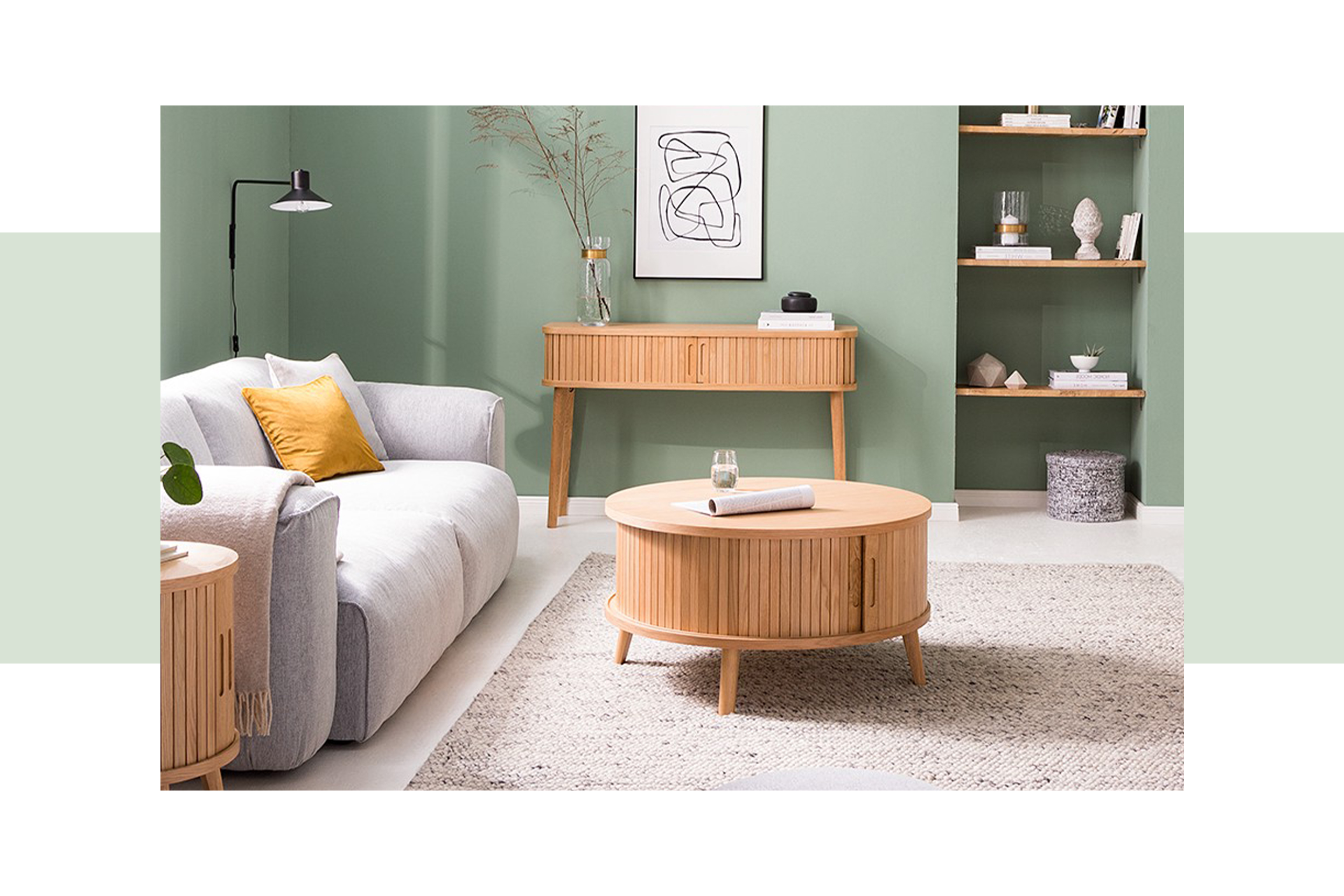 Graues Sofa mit elektrischer Sitztiefenverstellung und Wohnzimmermöbel aus hellem Holz vor einer Wand in Salbeigrün