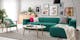 Salon avec canapé vert, coussins à motifs variés et tableaux colorés aux murs