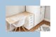 Werkhoek in de kinderkamer met witte houten meubels en vloerkleed met ikatpatroon