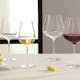 Weingläser mit Weißwein und Rotwein gefüllt auf einem weißen Tisch