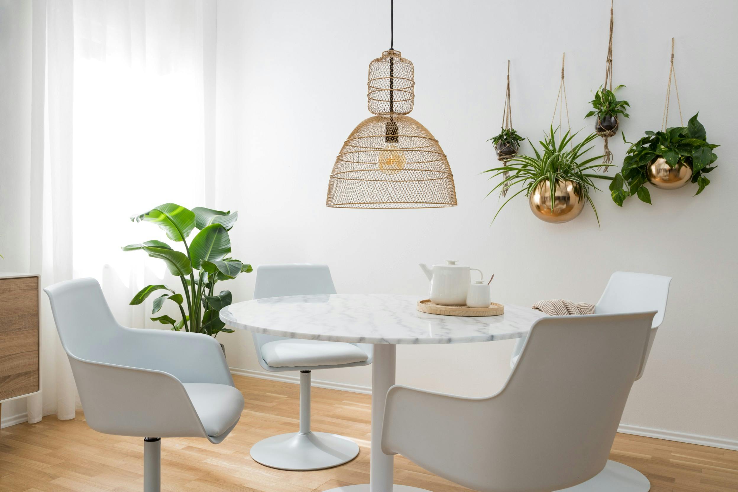 Essbereich mit rundem Esstisch, modernen Stühlen und verschiedenen Hängepflanzen