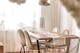 Chaises en velours couleur crème avec pieds dorés, lampadaire doré dans une salle à manger qui marie hygge et glamour 