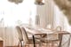 Crèmekleurige fluwelen stoelen en goudkleurige details, bijv. op stoelpoten en lampen, laten zien hoe je de eetkamer in hygge glam stylet