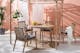 Gartenstühle und Gartentisch aus Holz mit Juteteppich, Leinen und Grünpflanzen im Boho-Look