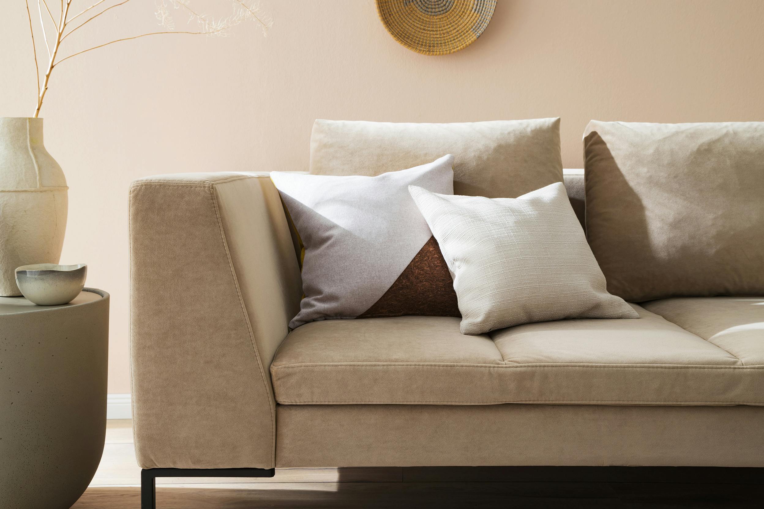 Sandfarbenes Sofa in Wohnzimmer eingerichtet in natürlichen Farbtönen