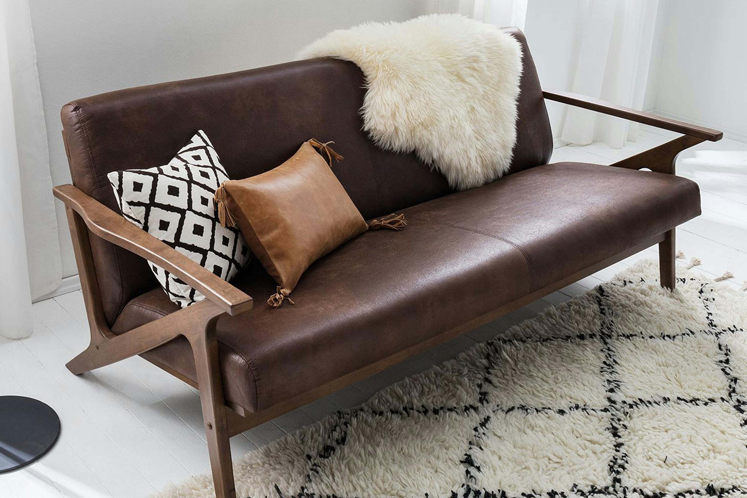 Braunes Sofa mit Dekokissen und Kunstfell