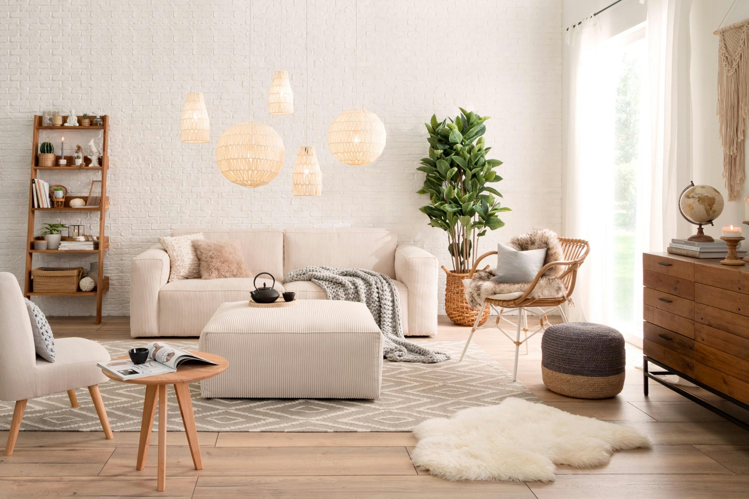 Wohnzimmer in hellen Farben und Holztönen mit Couch, Stuhl, Sessel, Hocker und Beistelltisch