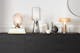 Lampes de table en verre structuré et de formes géométriques sur un buffet décoré avec style.