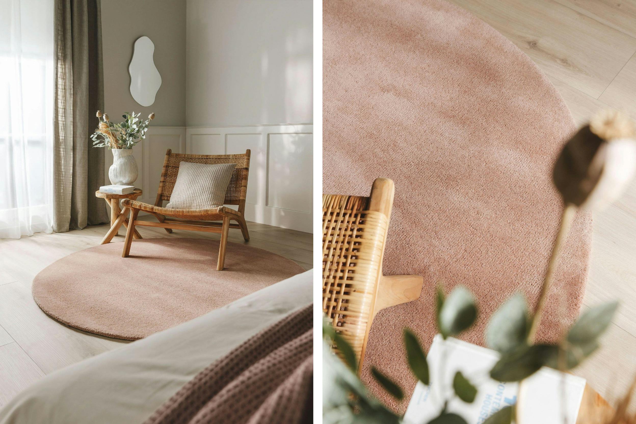 Geflochtener Loungesessel mit Vase, assymetrischem Spiegel und rundem rosa Teppich