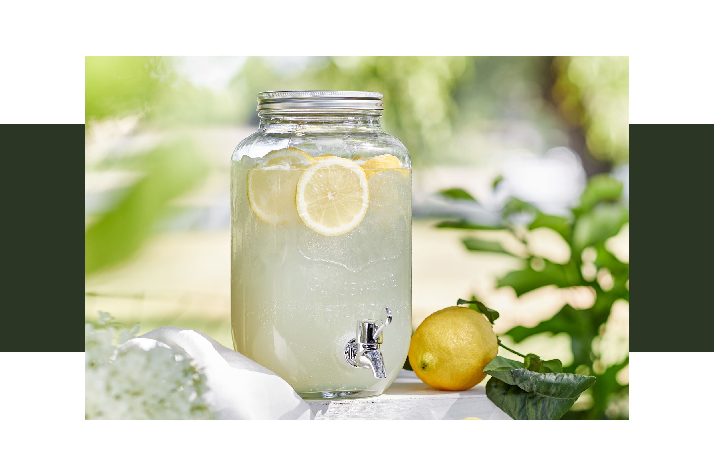 Ein großes Glas mit Zitronenlimonade und Zitronen