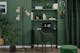 Slaapkamer met geïntegreerde werkhoek met groene meubels en gouden en zwarte elementen in de retro stijl.