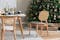 Eetkamer met meubels van Studio Copenhagen: een lichtkleurige houten eettafel met stoelen met rotan, een wit dressoir, een grijze fauteuil en glazen hanglampen.