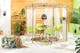Terrasse im Boho-Stil mit grün-schwarzen Gartenstühlen, einem Tisch im Industrial-Stil sowie einer Hängelampe aus Rattan, dazu viele Grünpflanzen, ein Pouf mit Pflanzenprints und Outdoor-Teppiche aus Jute.