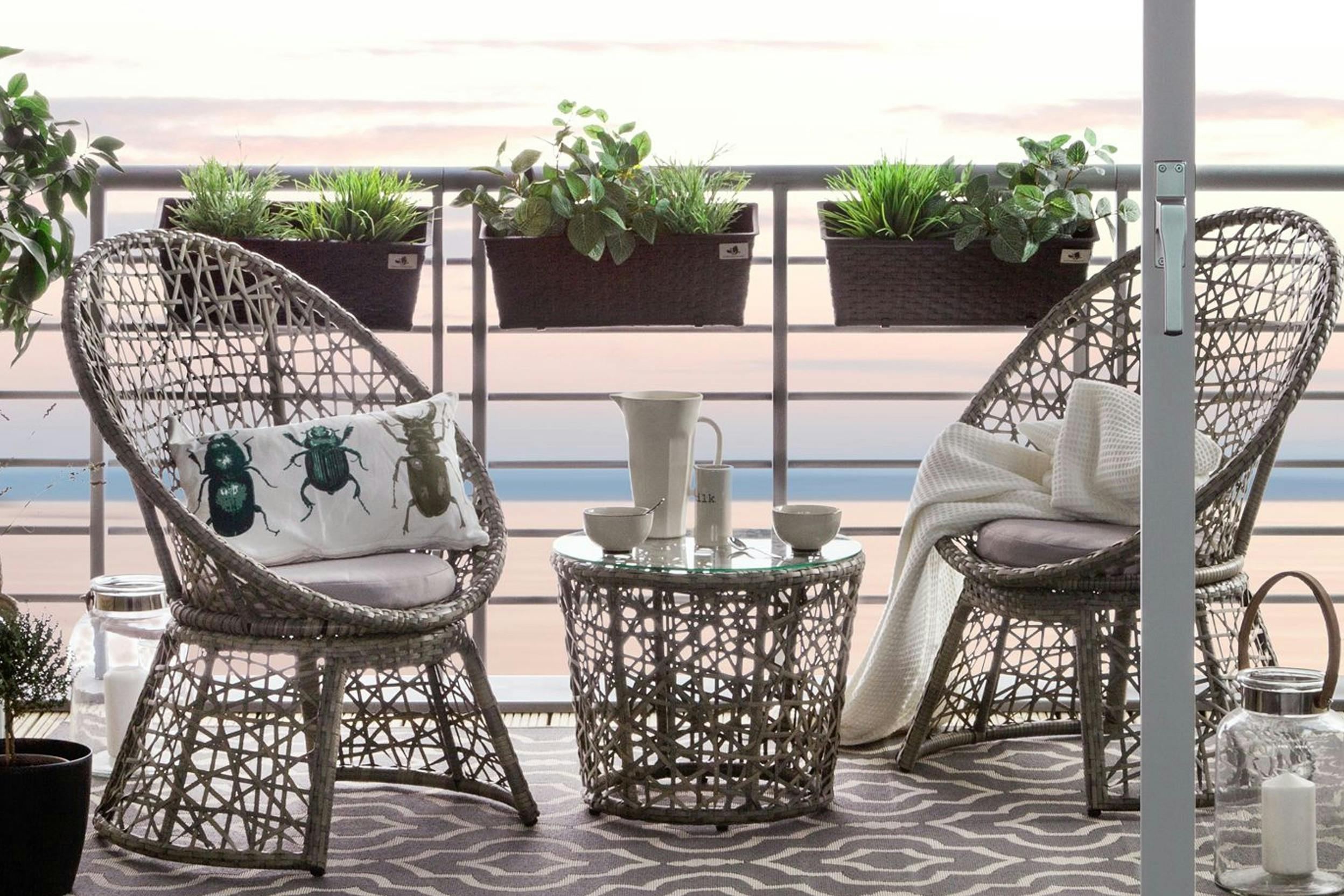 Balkonmöbel-Set aus Polyrattan auf Balkon mit Outdoor-Teppich