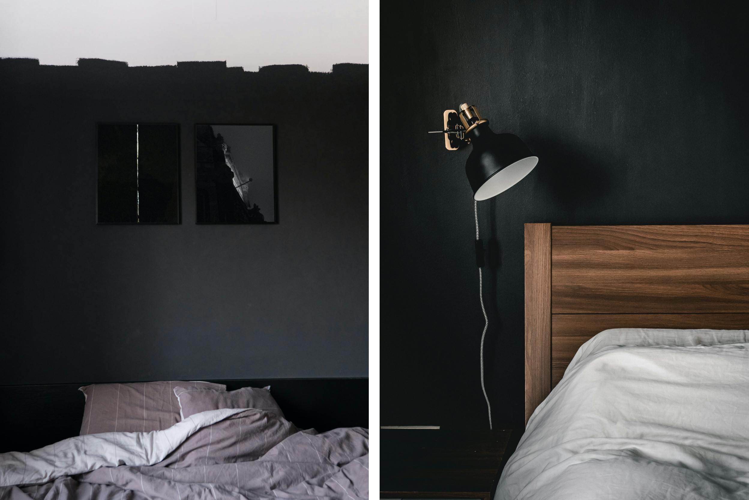 Mur noir dans une chambre à coucher avec plafond blanc, lit à sommier en bois, petits tableaux décoratifs noirs et lampe noire 