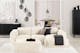 Salon noir et blanc avec canapé blanc Hudson de chez Studio Copenhagen sur un tapis fluffy blanc, avec meubles noirs posés devant des murs blancs et présentant des objets déco noirs et blancs.