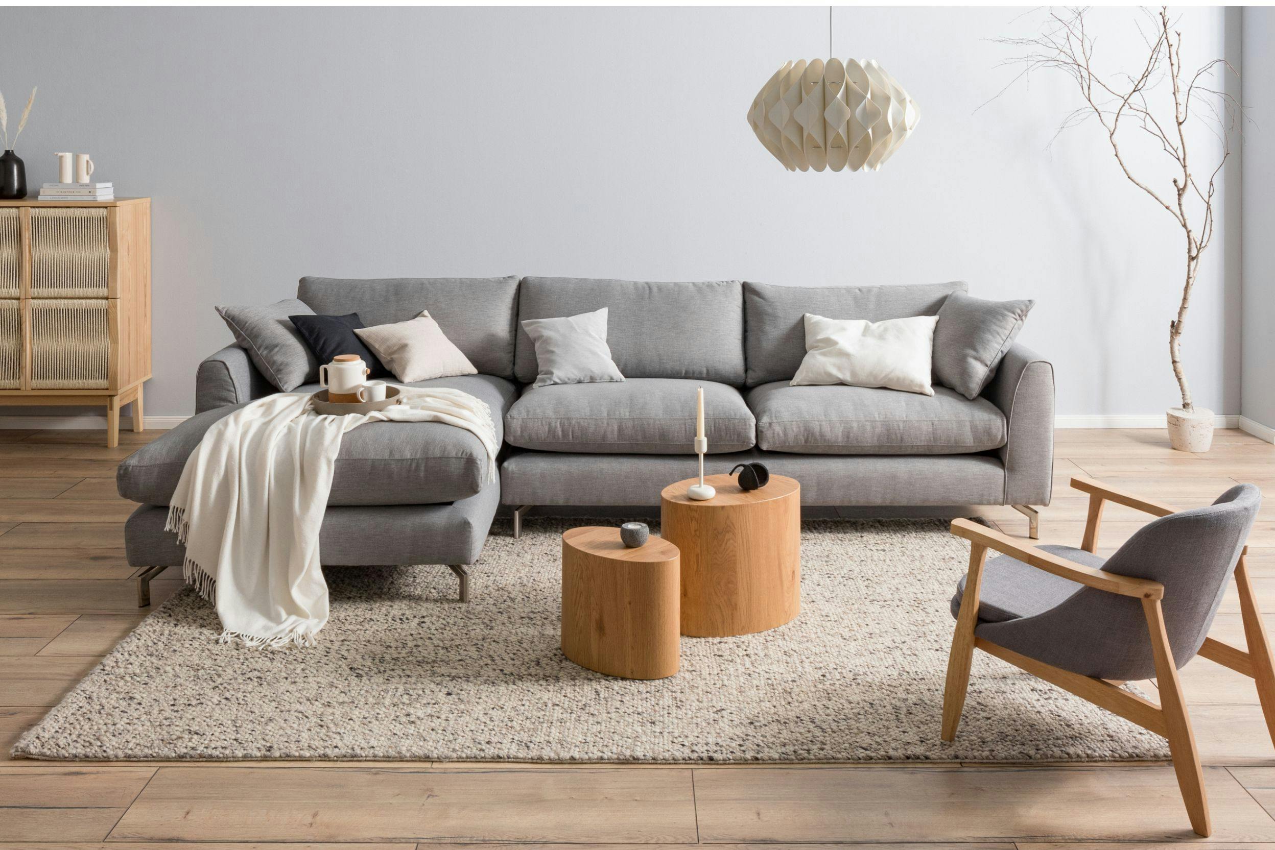 Photo d'un salon avec un canapé gris clair, des coussins blancs et un tapis beige
