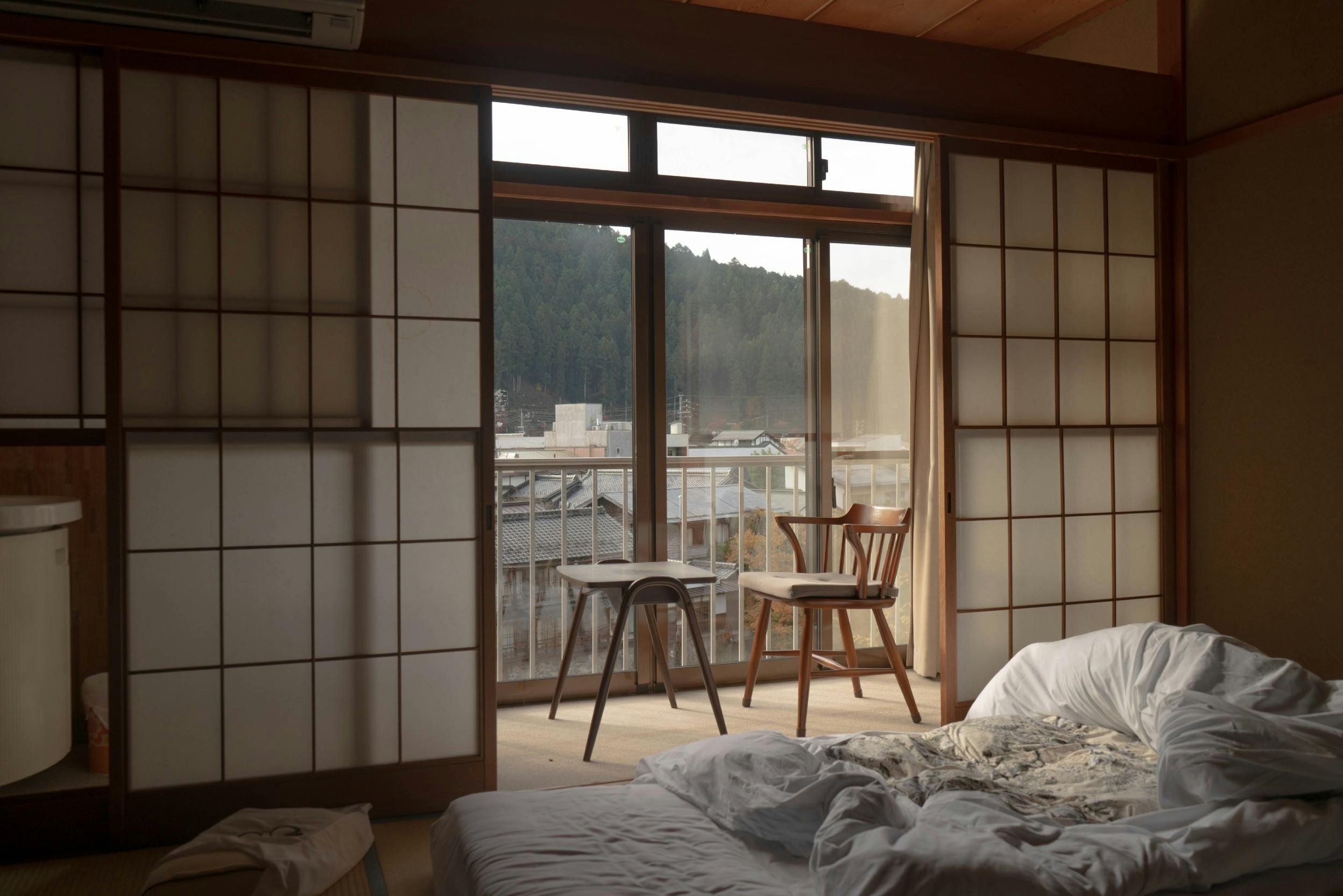 Chambre de style japonais, avec portes coulissantes, meubles en bois massif et futon au sol