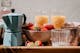 Tablett aus Massivholz mit Kaffeebereiter in Hellblau, Schale mit Erdbeeren, Trinkgläsern mit Saft (Marke: Butlers).