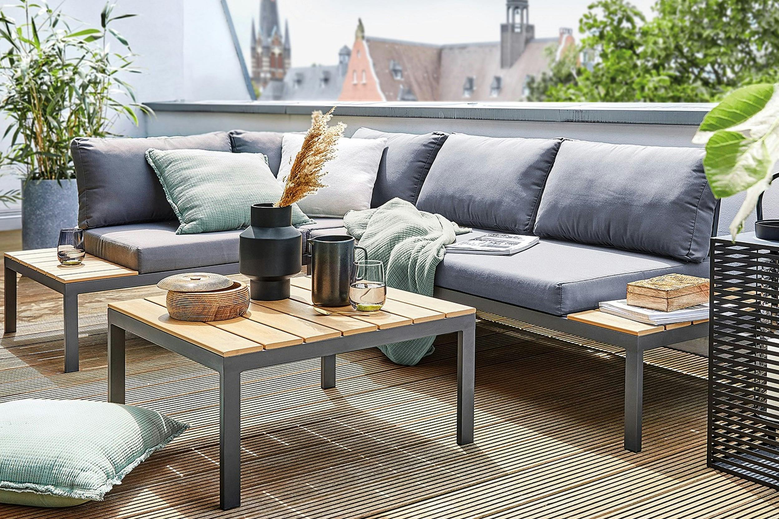 Loungebank met grijze kussens op een balkon