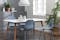 Salle à manger avec chaises bleues, table, objets déco et suspension tous trois de couleur blanche