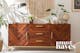 Musthave-dressoir Loga van kollected van acaciahout met voorkant met visgraatpatroon en goudkleurige meubelpoten en handgrepen.