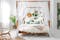 Chambre avec lit à baldaquin, linge de lit blanc, coussin et papier peint à l'imprimé végétal, fauteuil en osier