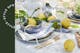 Tafel met Limoncello Spritz in gecanneleerde glazen van BUTLERS, plus goudkleurig bestek, blauwgrijs servies en sappige citroenen als decoratie.