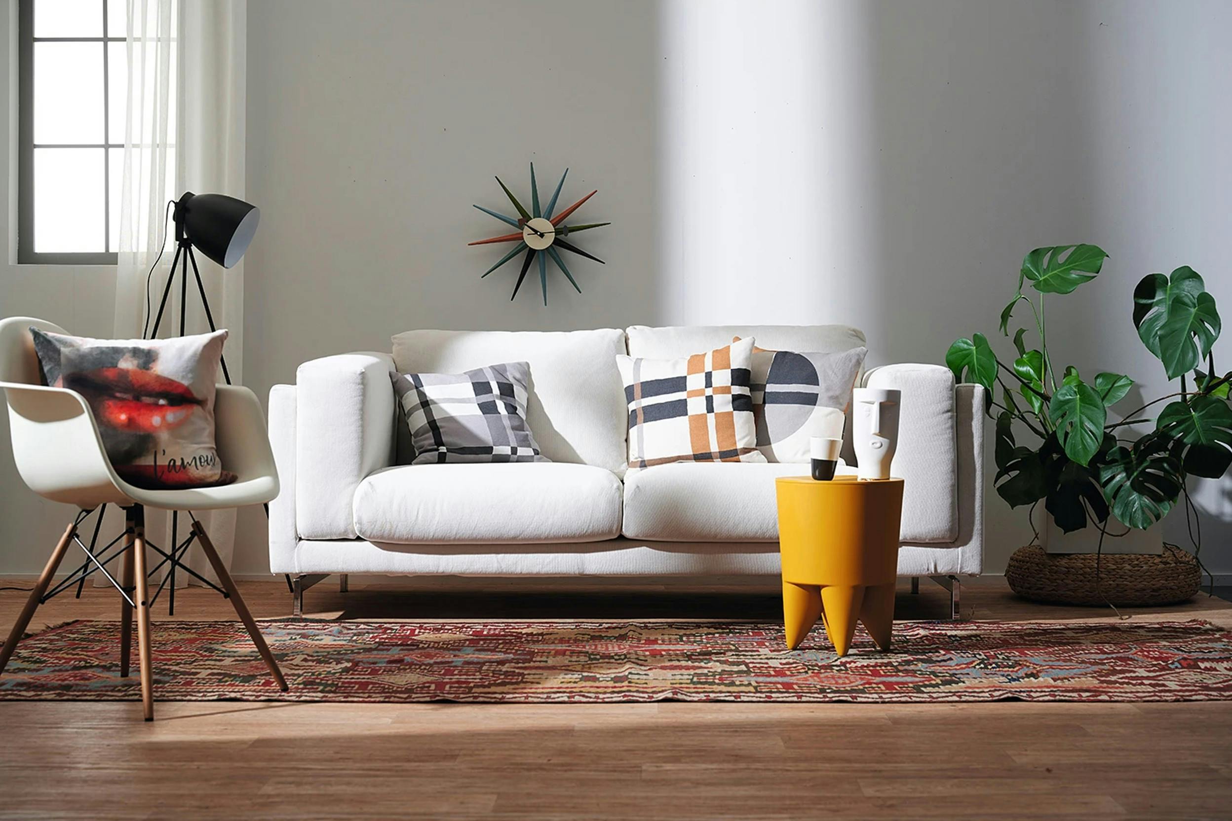 Un soggiorno con una sedia bianca e un tavolo di legno con quadri alle  pareti.