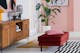 Sideboard Deva der home24 Exklusivmarke kollected mit Tischleuchten aus Glas im Retro-Stil, dazu ein Kandinsky-Wandbild, eine Grünpflanze in einem weißen Pflanzentopf, dazu zwei Teppiche und ein roter Polsterhocker Fort Dodge mit rosafarbenem Kissen.