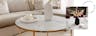 Salon dans des nuances de beige avec table basse en marbre blanc avec une structure en métal doré