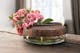 Lage vaas van glas met hout en roze bloemen