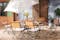 Terrasse mit Gartentisch, Gartenstühlen und Gartenbank aus Akazienholz mit hellblauen Sitzkissen, dazu ein weißer Sonnenschirm, ein gemusterter Outdoor-Teppich und Deko.