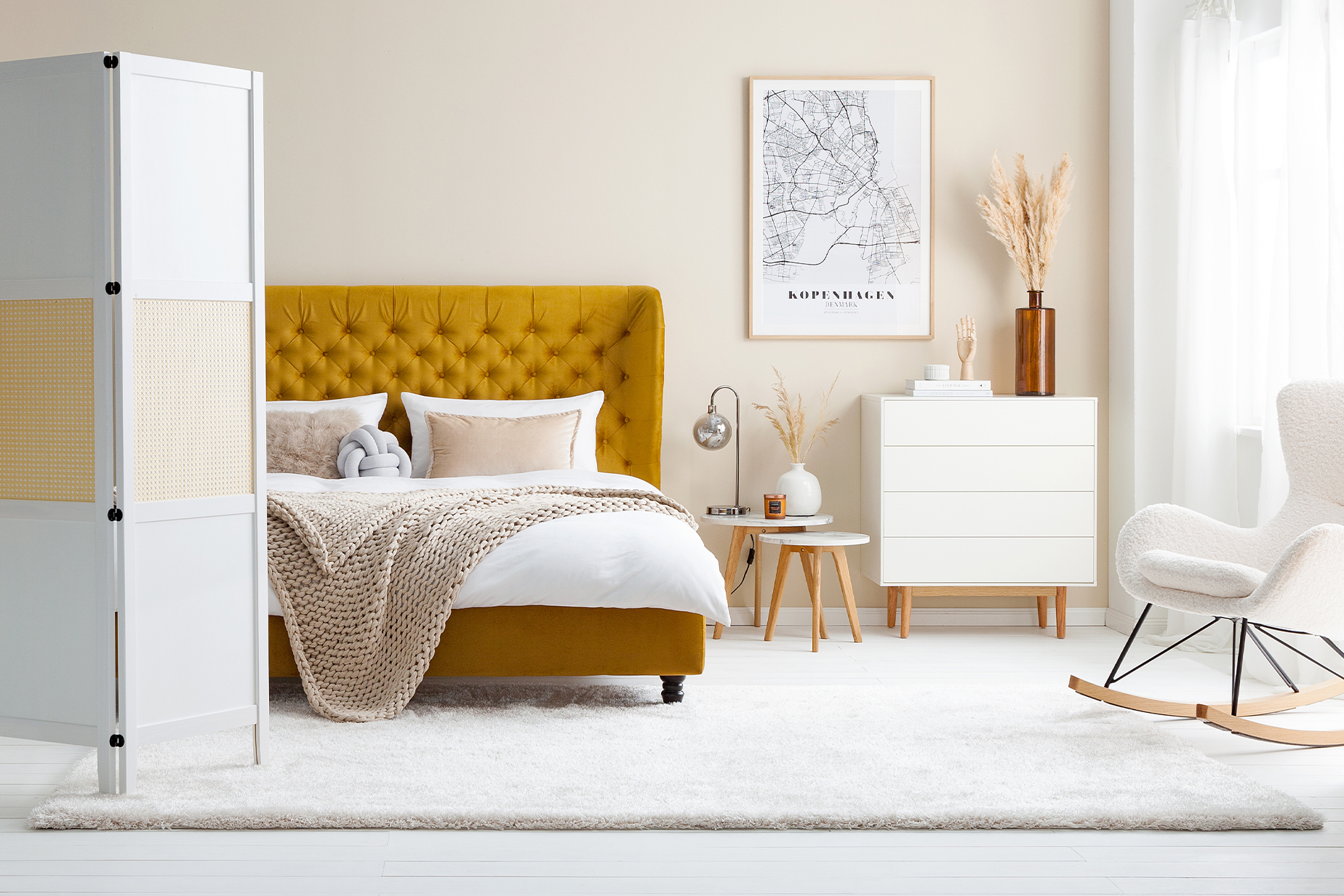 Schlafzimmer im Skandi-Stil mit senfgelbem Polsterbett aus Samt mit Chesterfield-Knöpfung und vielen flauschigen Textilien