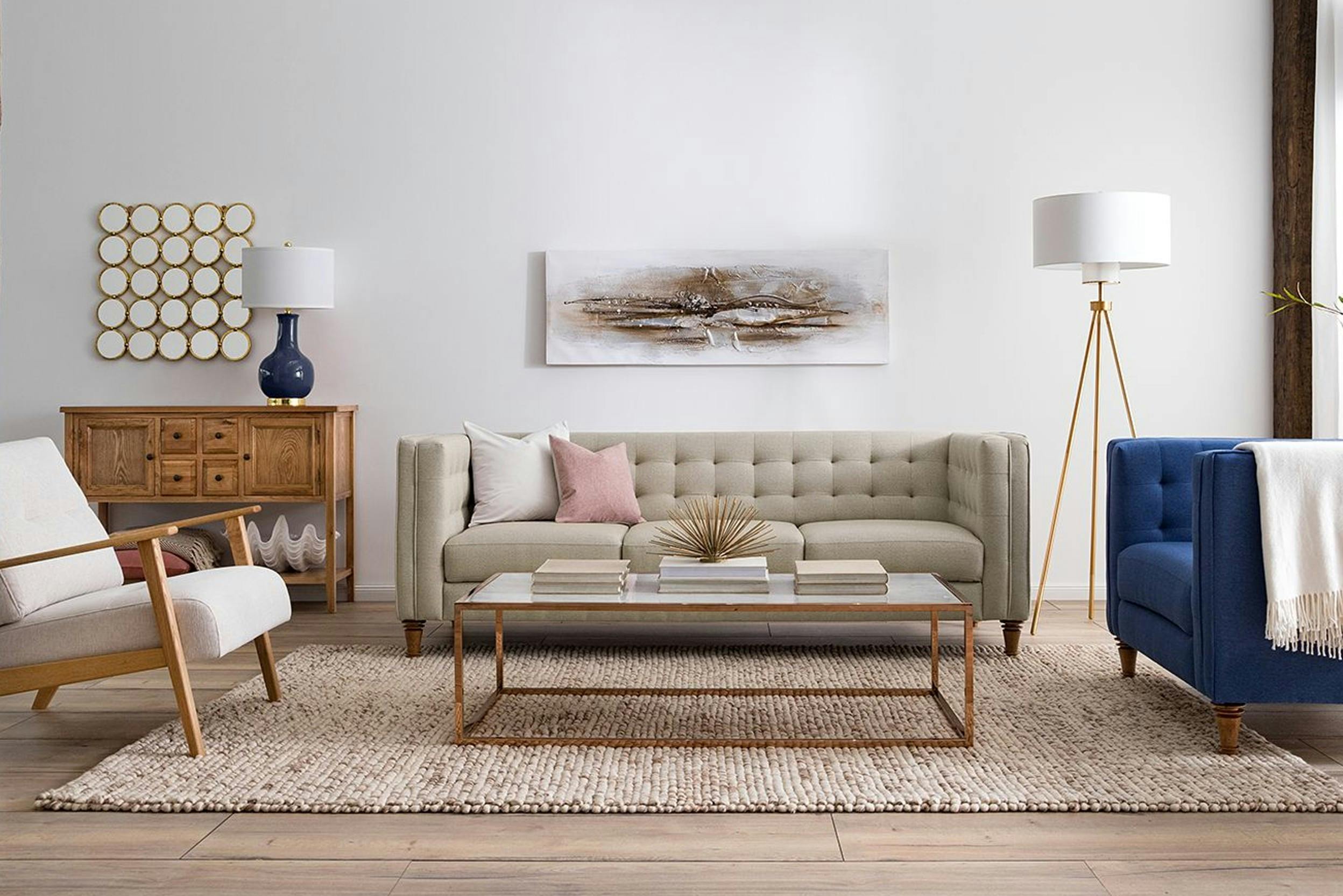 Rechteckiger Couchtisch auf Teppich stehend in Wohnzimmer mit heller Couch, blauem Sessel und Skandi-Sessel