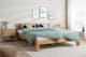 Helles Schlafzimmer mit Futonbett aus Holz und grüner Bettwäsche