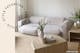 Wohnzimmer in Neutrals zeigt das cremefarbene 2-Sitzer-Sofa Hudson mit gerundetem Polster und halbrundem Couchtisch aus Holz; das hellgraue Sofa in Halbmondform beweist, dass Ecksofas auch rund sein können