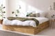 Massief houten bed met bedbodem, wit beddengoed en groene deken van wol