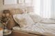 Neutrale slaapkamer met gestoffeerd bed en beddengoed in beige en grijs