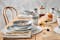 Table de petit déjeuner avec vaisselle en grès légèrement bleuté BUTLERS : mugs, grandes assiettes, petites assiette et assiettes creuses. Sets de table bohème, couverts dorés, cafetière à piston, confiture et viennoiseries.