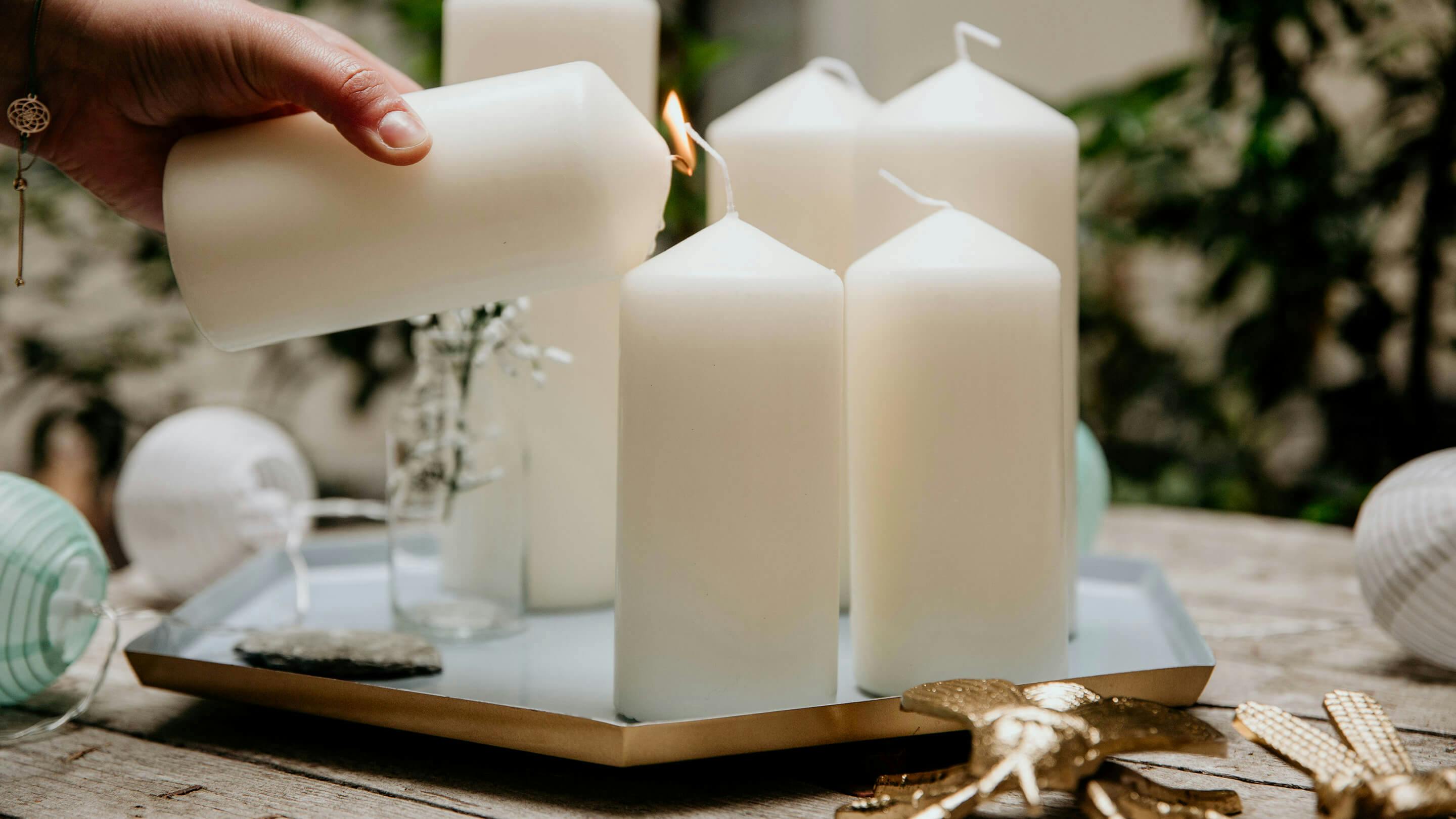 Weiße Kerzen und goldfarbene Dekorationsobjekte für die Terrasse (Marke: Butlers).