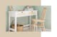 Une coiffeuse blanche aux tiroirs en cannage trouve sa place devant un mur vert sauge et une chaise en bois naturel.